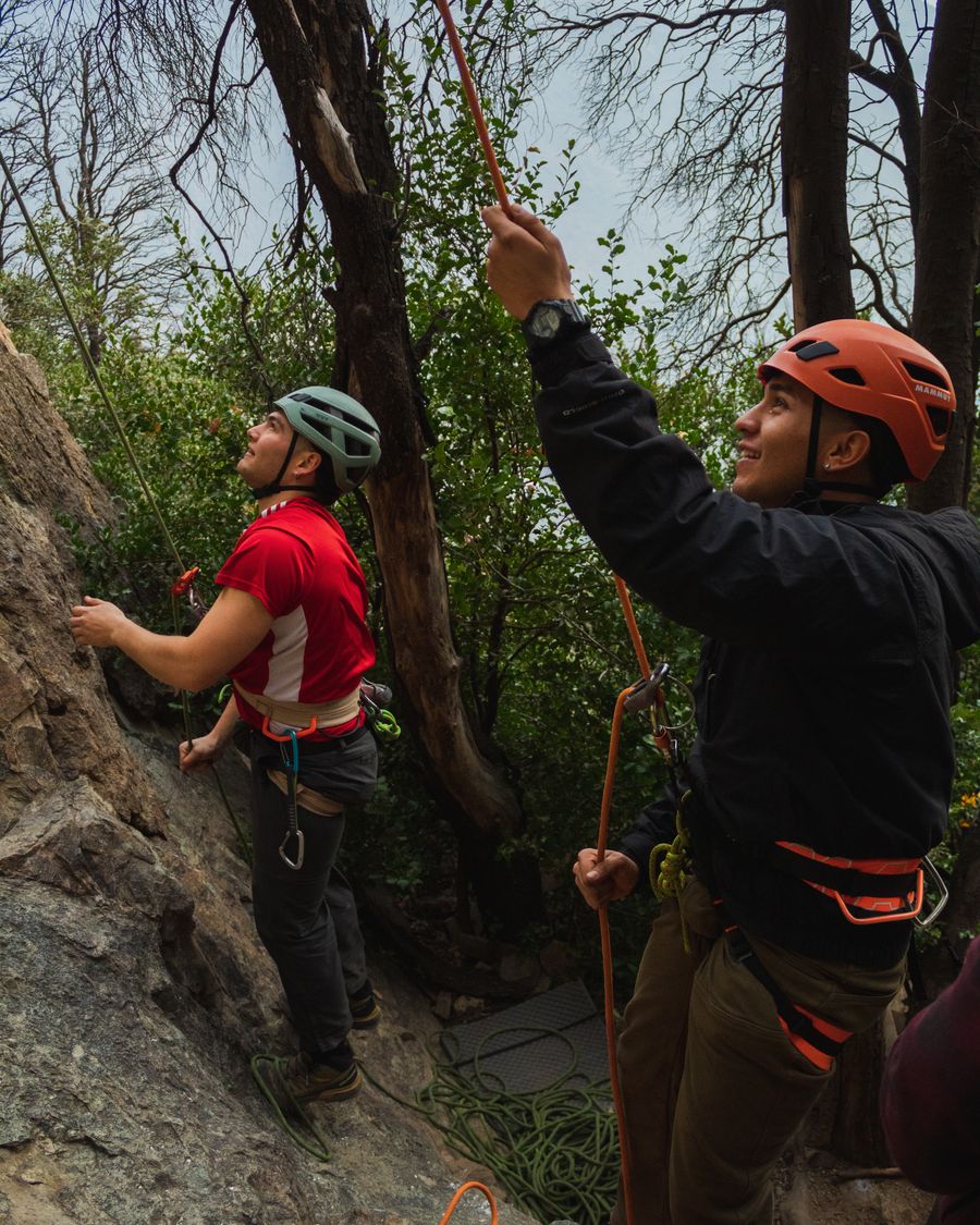 Escaladores con casco sonriendo en el bosque del Cajón del Maipo