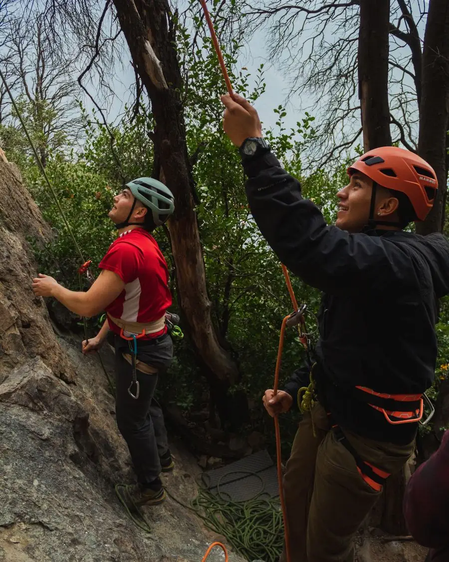 Escaladores con casco sonriendo en el bosque del Cajón del Maipo