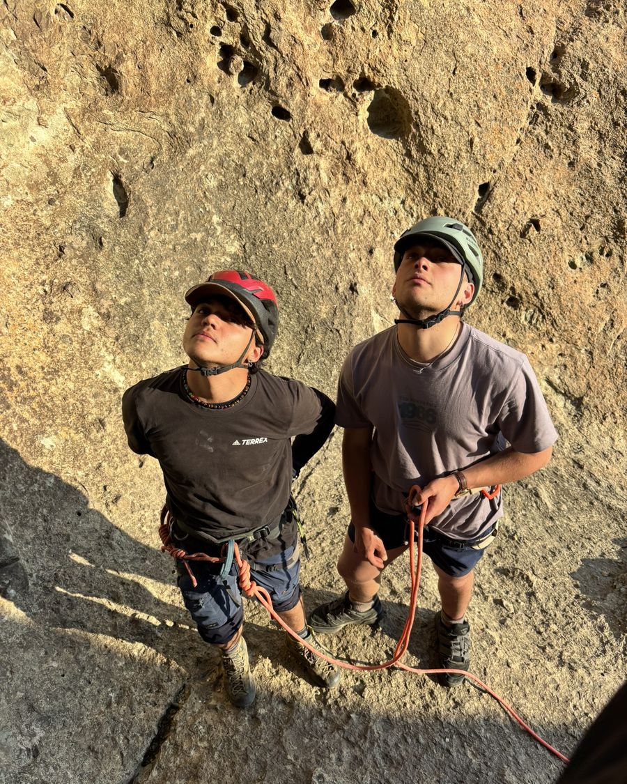 Dos participantes con casco mirando la vía antes de escalar
